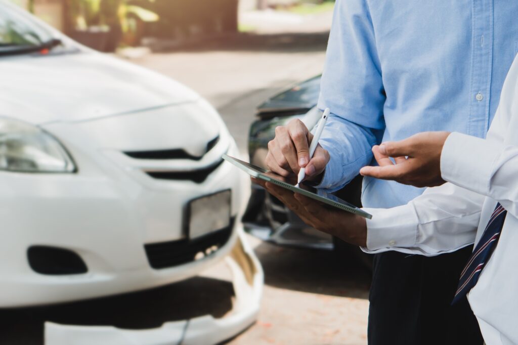 Car insurance concept.Business man filing signature on report claim form process after accident.