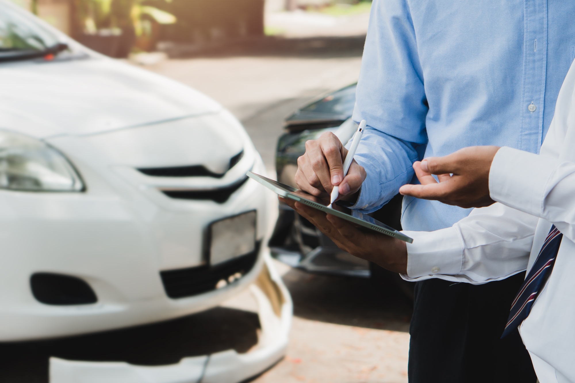 Car insurance concept.Business man filing signature on report claim form process after accident.