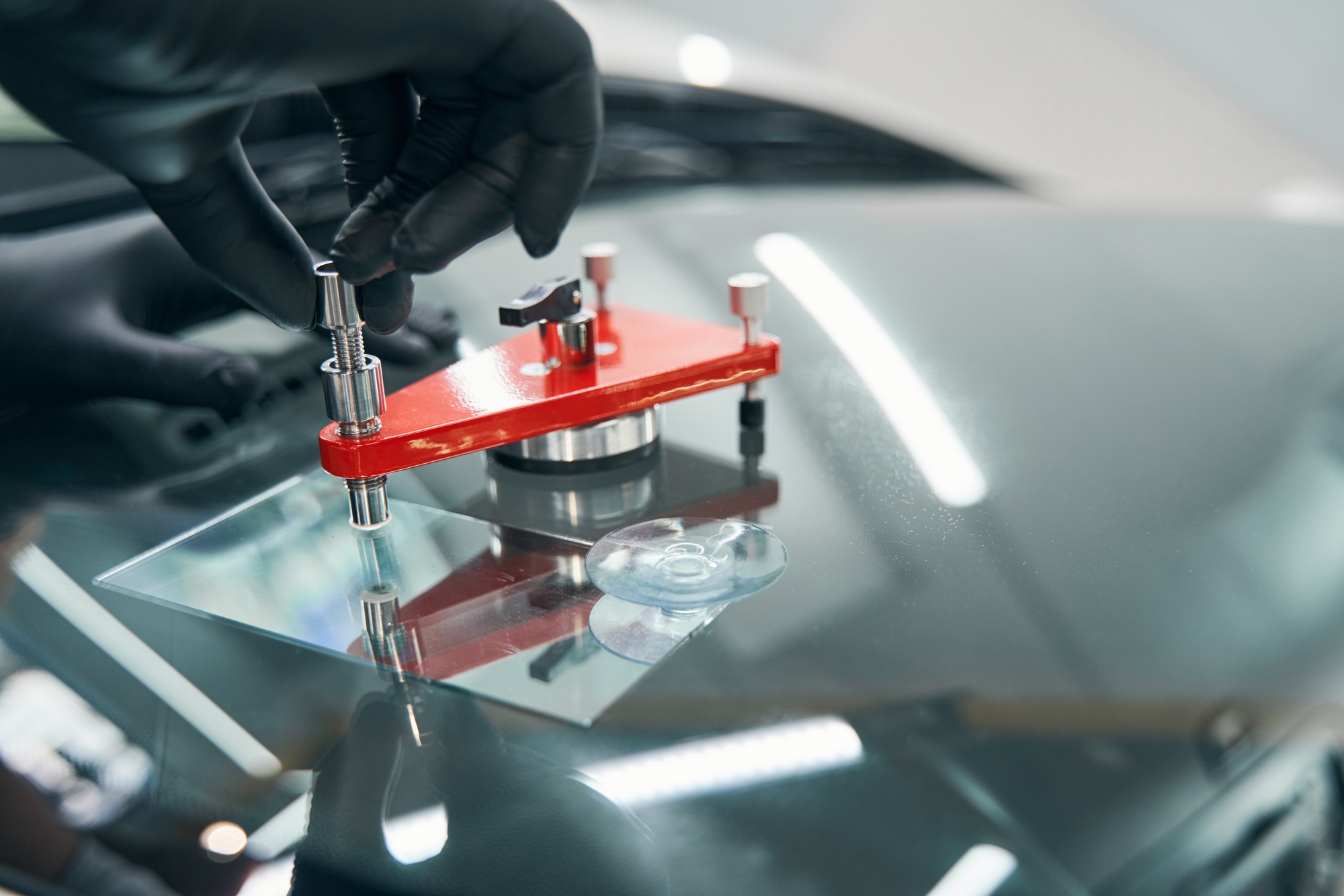 Closeup repair of cracked car windshield. Auto windshield crack fixing